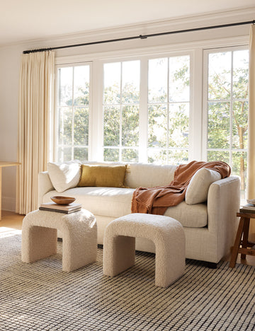 #color::white-basketweave #size::queen | The Lotte White Basketweave queen-sized sleeper sofa sits atop a grid rug with two boucle ottomans