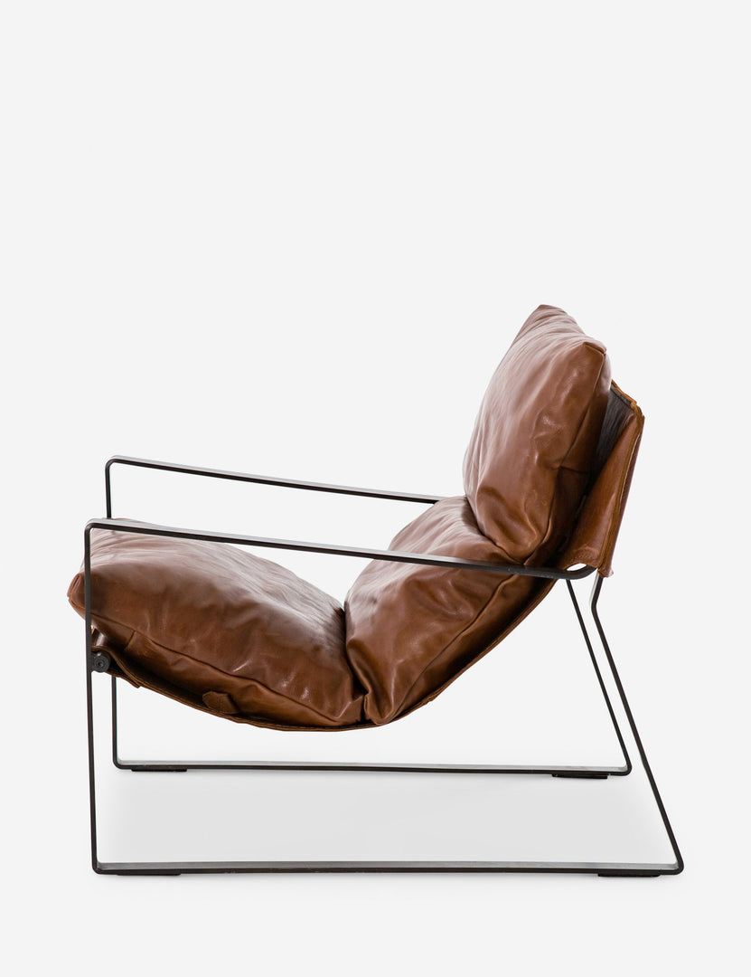 | Side view of brown leather Marlyne sling-back accent chair with black metal frame