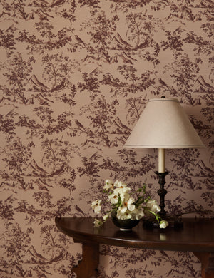 A console table with table lamp sit infront of a wall covered with the Dors Grasscloth Wallpaper by Jake Arnold