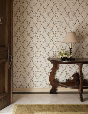 An entryway featuring a wooden console table and the Tillar botanical lattice pattern Wallpaper by Jake Arnold