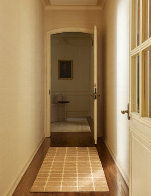 A hallway featuring the Beddow Flatweave Jute Grid Rug by Jake Arnold in the runner size.