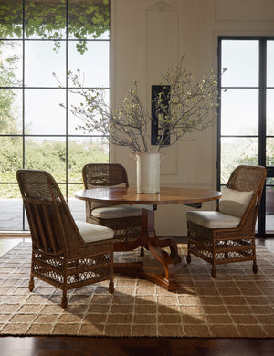 A dining table and chairs styled with the Beddow Flatweave Jute Grid Rug by Jake Arnold.