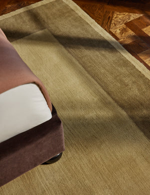 The Deller Hand-Loomed Wool Rug by Jake Arnold styled under a velvet bed frame