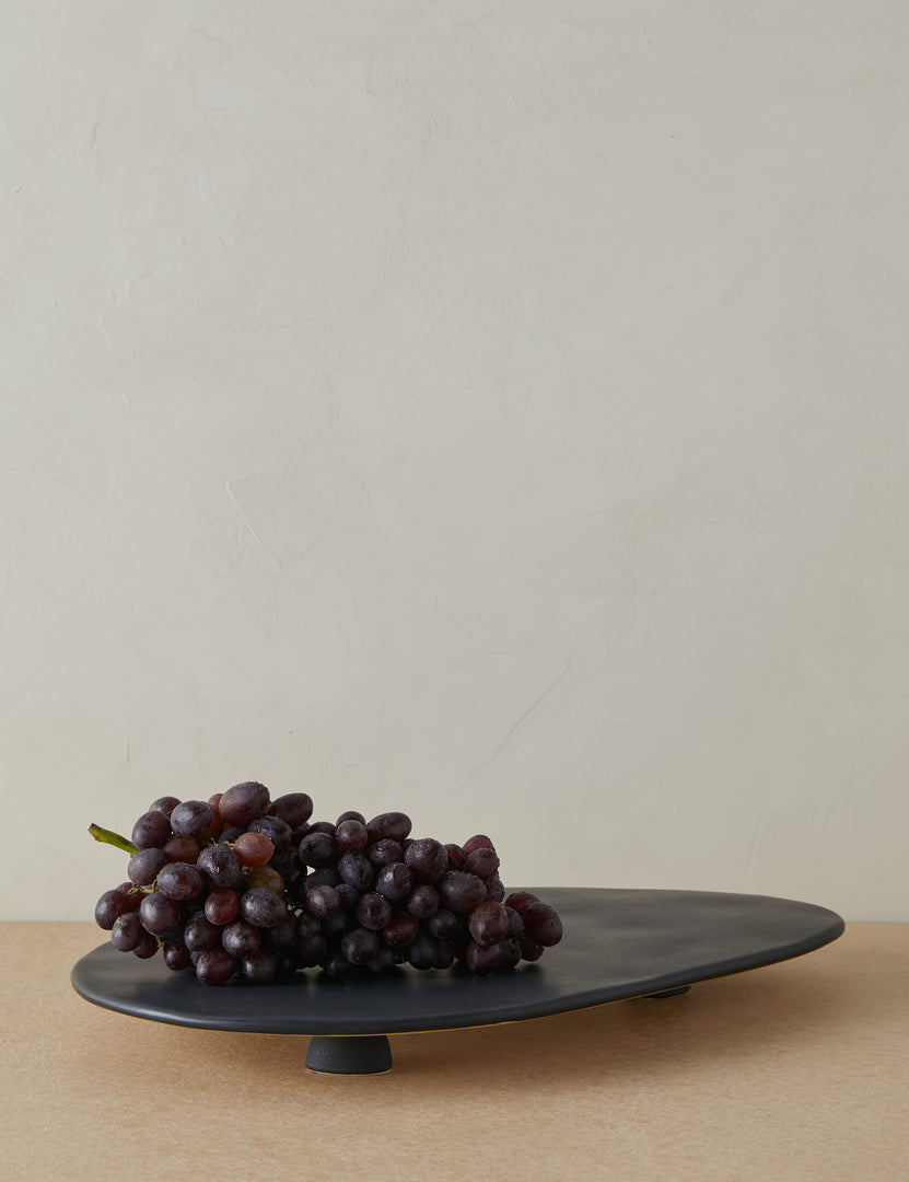 #color::black | Footed serving display tray in black holding a bunch of grapes