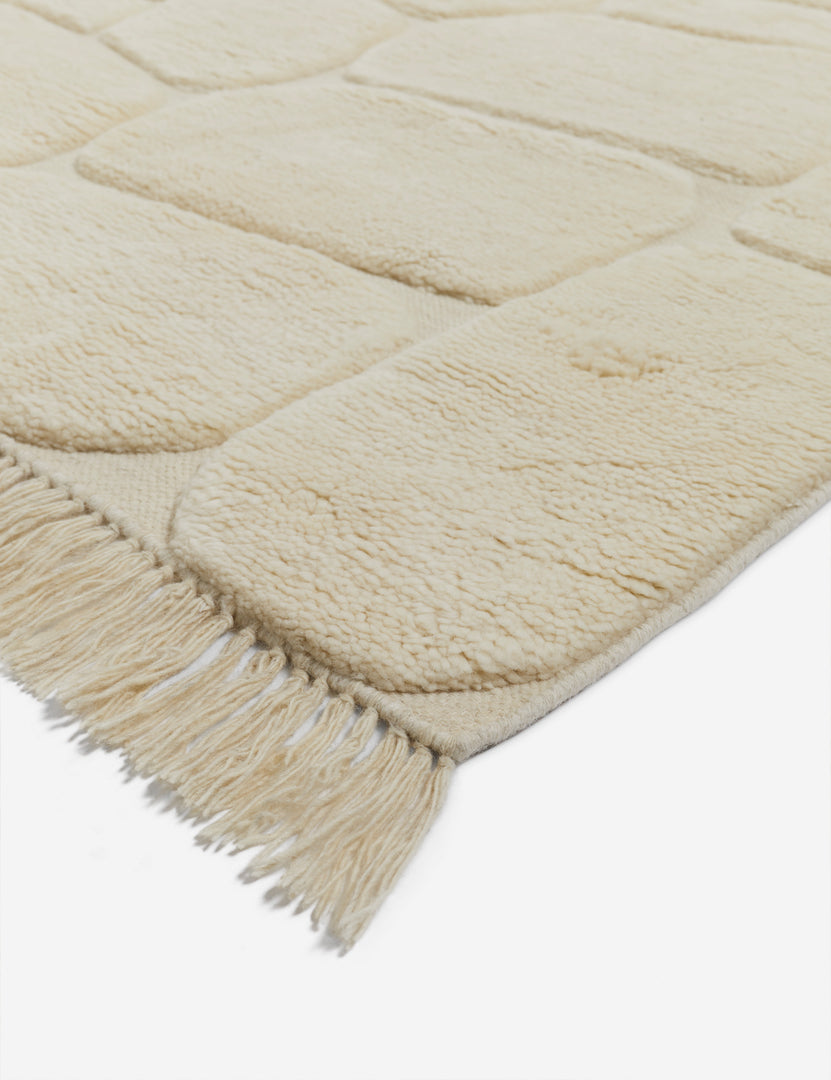 #size::6--x-9- #size::8--x-10- #size::9--x-12- #size::10--x-14- #size::12--x-15- | Close corner view of the Kivi raised cobblestone pattern fringe wool area rug