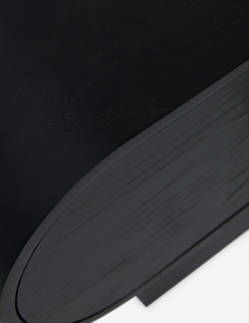 #color::black | Close up view of the Laughlin retro pill shaped nightstand in black
