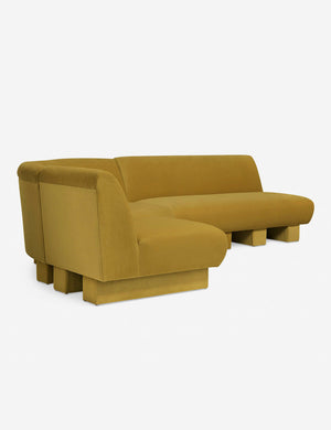 Angled view of the Lena left-facing yellow velvet sectional sofa with upholstered beam legs.