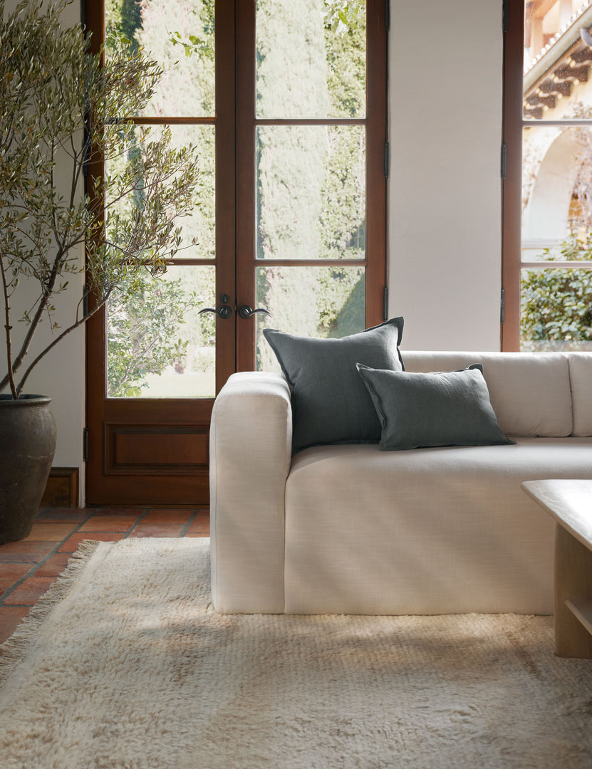 #color::dusty-blue #style::square | The arlo Dusty Blue flax linen pillow in its lumber and square sizes sit together on a natural linen sofa in a room with tall french doors 