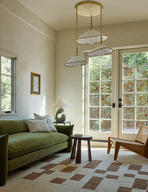 Arroyo Mixed-Material Chandelier by Elan Byrd hanging above a coffee table in a living room.