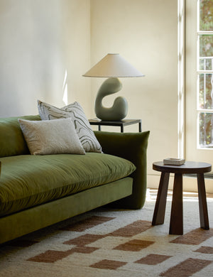 Saguaro Sculptural Ceramic Table Lamp by Elan Byrd styled on a side table next to a sofa.