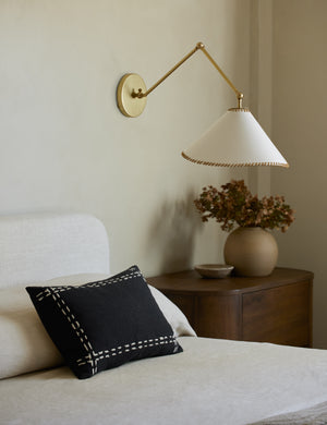 Accord Black Linen Lumbar Pillow by Elan Byrd styled on a bed.