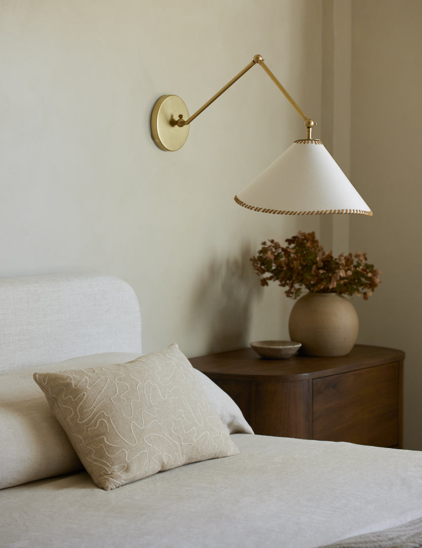 #color::brass | Arroyo Mixed-Material Adjustable Arm Sconce by Elan Byrd styled above a bedside table.