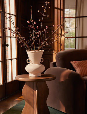 Philia wide beaded rim loop handle ceramic vase by Aimee Song styled on a side table next to a chaise lounge chair
