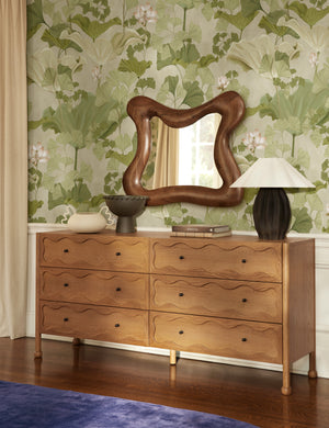 Lotus lush botanical wallpaper by Aimee Song on a wall behind a dresser in a bedroom