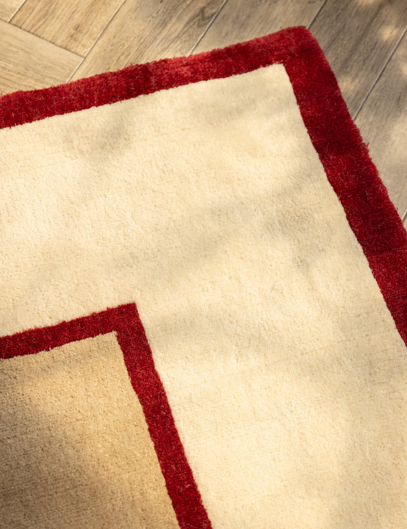#color::garnet #size::6--x-9- #size::8--x-10- #size::9--x-12- #size::10--x-14- #size::12--x-15- | Close up of the corner of the Deller Hand-Loomed Wool Rug by Jake Arnold