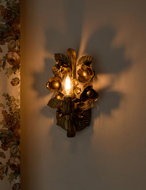 Garda ornate floral metalwork wall sconce by Heidi Caillier with the light on