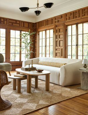 Living room featuring the Harlowe Sofa, nesting light wood coffee tables and a jute rug.