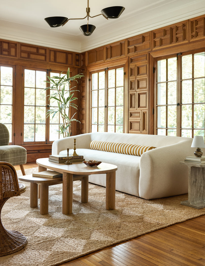 | Living room featuring the Harlowe Sofa, nesting light wood coffee tables and a jute rug.