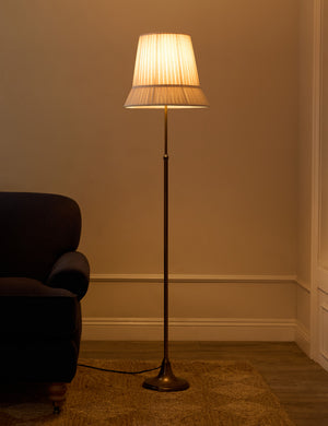 Lily slim metal stem adjustable height floor lamp by Heidi Caillier with the light turned on