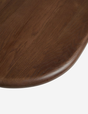 Close up view of the Nave modern sculptural red oak dining table by Aimee Song