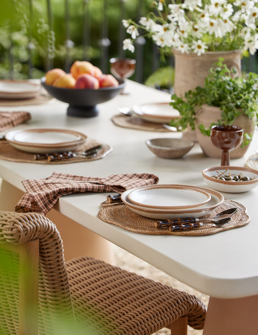 #color::ivory-and-terracotta | Keating sculptural two-toned outdoor dining table set for an outdoor dinner.