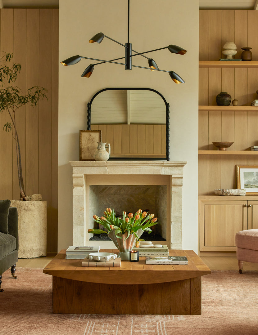 #color::black | Topia arched carved wood mantel mirror by Ginny Macdonald in black hung above a fireplace in a livingroom.