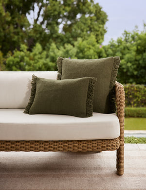 The lumbar and square sizes of the Thorpe outdoor pillow in moss styled on an outdoor sofa.
