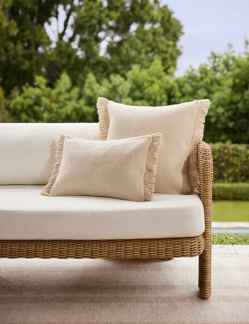 #color::ivory #style::square #style::lumbar | The Thorpe chunky woven fringed ivory outdoor pillow in the square and lumbar sized styled on an outdoor sofa.