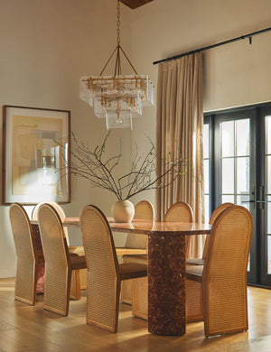 Eight Kapok woven cane sculptural dining chair by Carly Cushnie styled around a large marble dining table.
