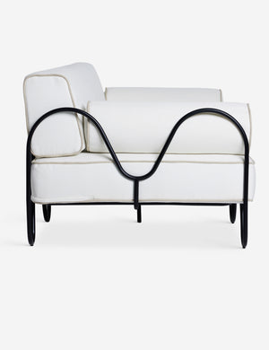 Side profile of the Angled view of the Peggy sculptural iron frame and white cushion outdoor sofa.