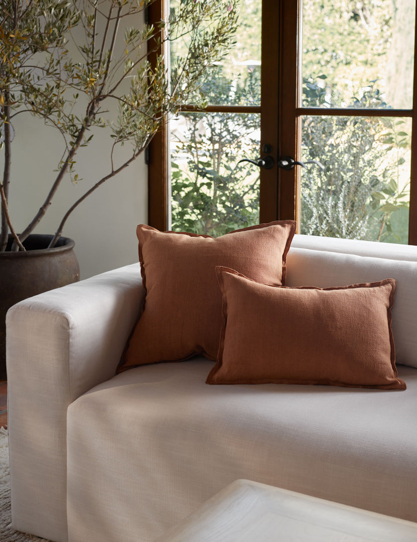 #color::burnt-orange #size::square | The arlo Burnt Orange flax linen pillow in its lumber and square sizes sit together on a natural linen sofa