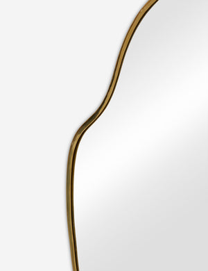 The gold curved frame on the large puddle mirror