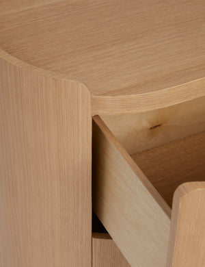 Close up view of open drawer of the Raphael modern rounded natural wood two drawer nightstand