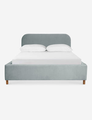 Solene Dove light blue velvet platform bed with an arched headboard and oak wood legs