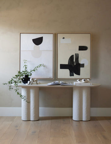 #size::24--x-32- #size::30--x-40- #size::40--x-54- | The In Pursuit Print hangs next to a white wall art above a white sideboard with a black vase and stack of books