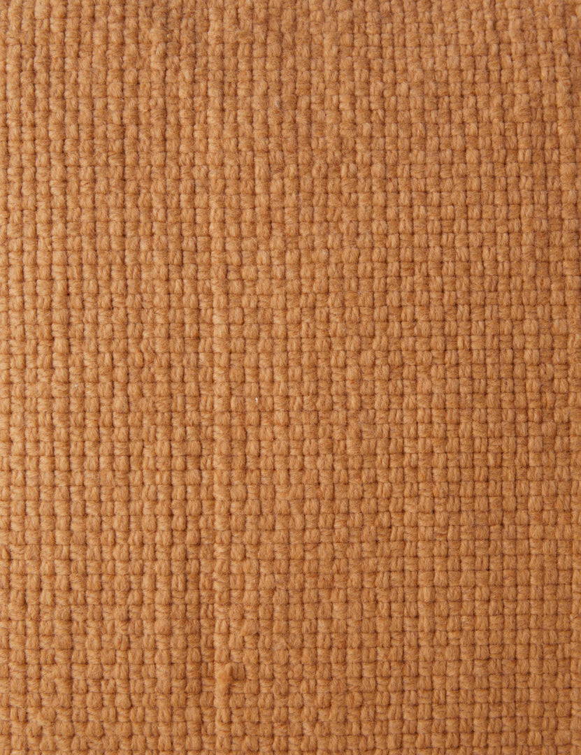#color::terracotta #style::square #style::lumbar | Close up of the Thorpe chunky woven fringed outdoor pillow in terracotta.