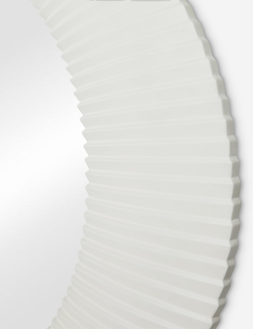 #color::white | Close up of the Whitaker white asymmetrical oval wall mirror.