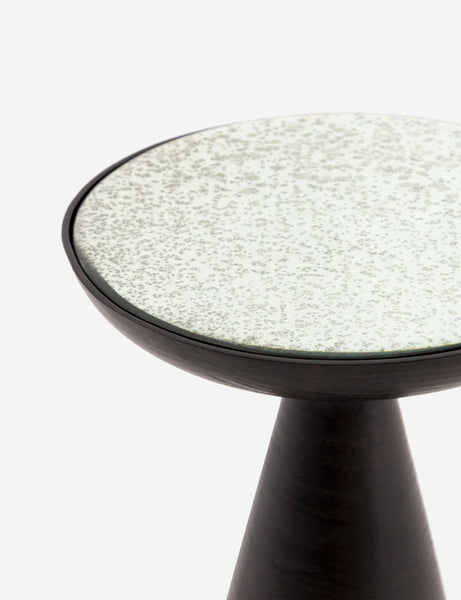 | Close-up of the upper-half of the Bridget bronze pedestal side table with mirror ash glass top