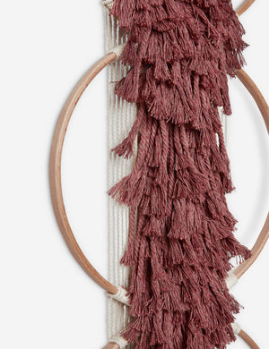 Close-up of the tasseled material on the Studio Nom Lwazi brick red woven Wall Hanging by nom