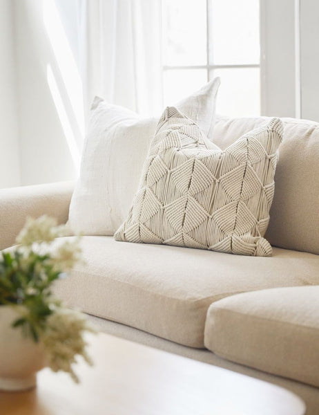 #size::20--x-20- | The Norala solid white handmade square throw pillow sits on a natural linen sofa with a white throw pillow behind it