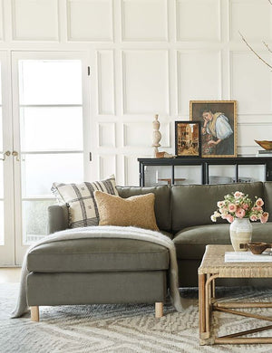  The Belmont left-facing loden gray linen sectional sits atop a gray and white patterned carpet in a room with accented walls