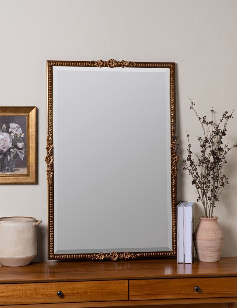 #color::gold | Cantara gold rectangular floral detailed framed decorative wall mirror leaning against wall on top of a table