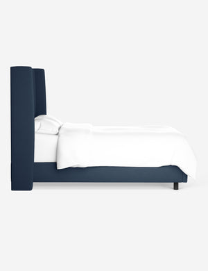 Side view of the Adara navy linen upholstered bed.