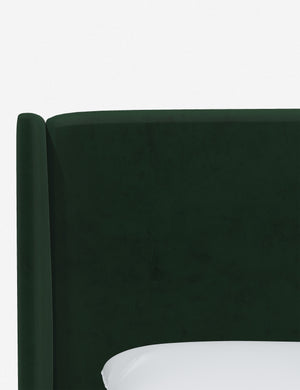 Close-up of the subtle winged headboard and trim lines on the Adara emerald velvet upholstered bed.