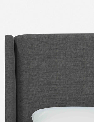 Close-up of the subtle winged headboard and trim lines on the Adara gray linen upholstered bed.