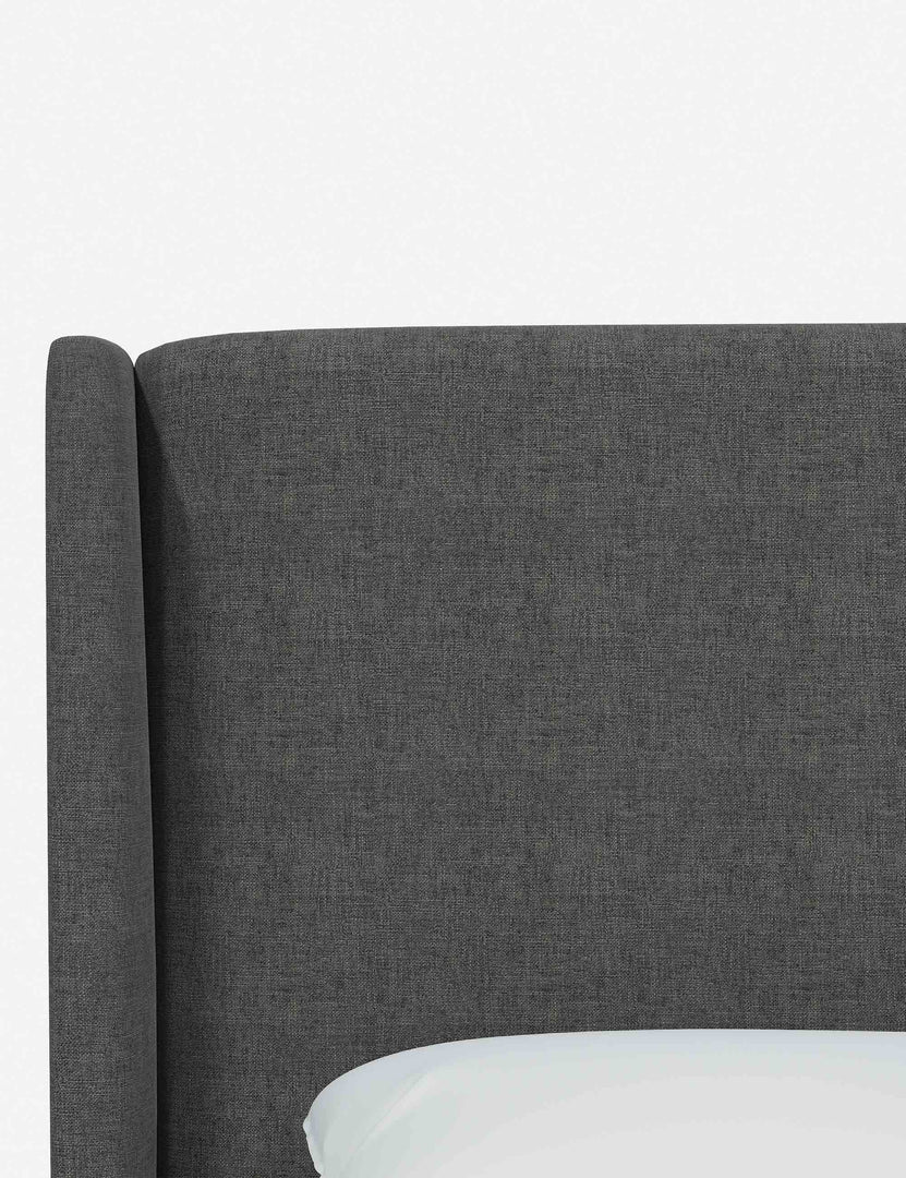 #color::charcoal-linen #size::king | Close-up of the subtle winged headboard and trim lines on the Adara gray linen upholstered bed.