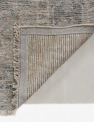 Close-up of the corner of the Ismenia distressed persian rug with fringed ends with the bottom folded over