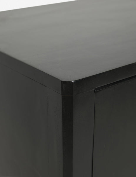 | Close-up of the joint work on the upper left corner of the Anabella black wood console table with silver drawer pulls