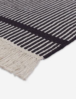 Close-up of the thick fringe on the Ines handwoven black-and-white striped mat