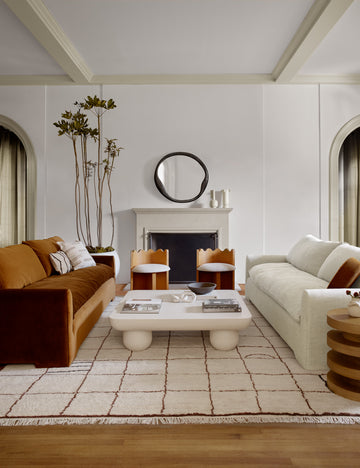 #color::Cognac-Velvet  | The Rupert cognac velvet sofa sits across an ivory linen sofa with two scalloped chairs and a square white coffee table in between